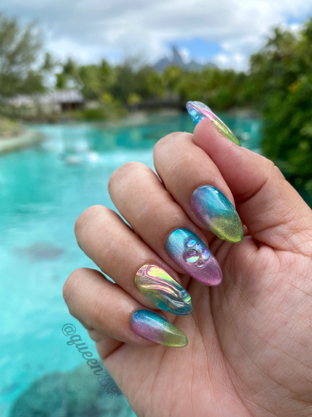 a hand holding a manicure with a colorful design on it