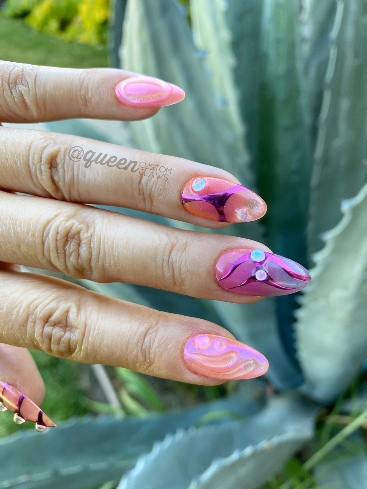 a hand with a pink and blue manicure with a flower on it