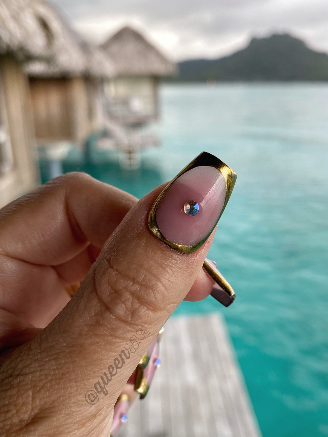 picture of a hand and nails showing custom handmade gel nail designs.  this design features a Natural shimmer base and subtle blush aura heart encased in a chrome bezel. You can choose with or without gems