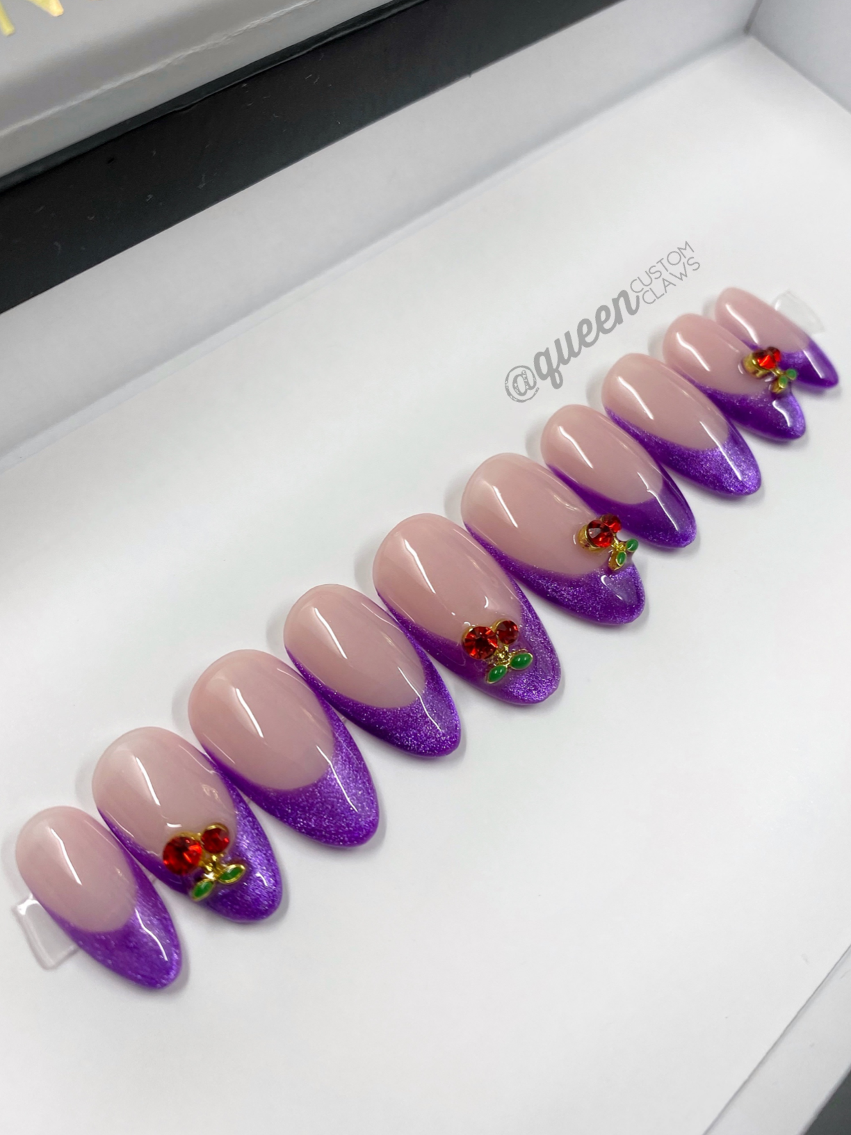 a display case with purple and pink press on nails