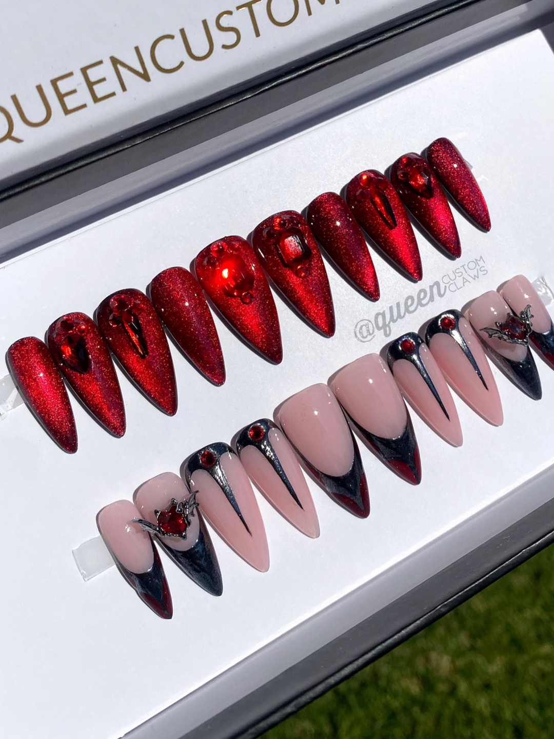 a display of handmade red and black stiletto press on instant acrylic nails