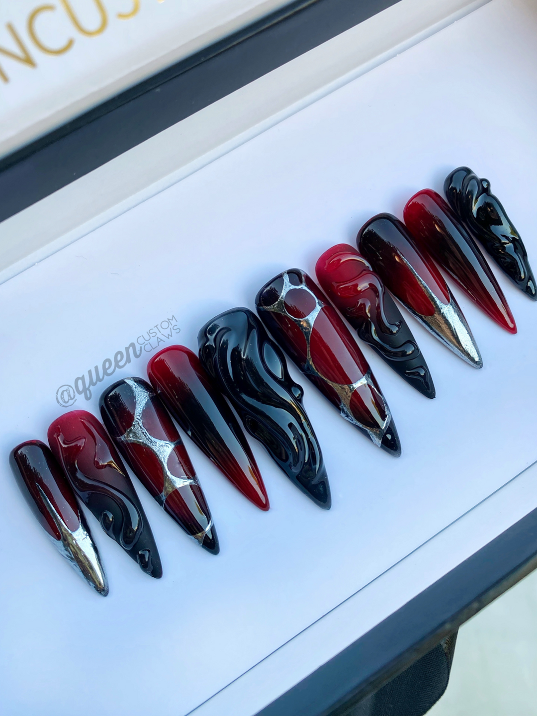 a picture of red and black vampy press on nailsdispalyed in their gift storage box